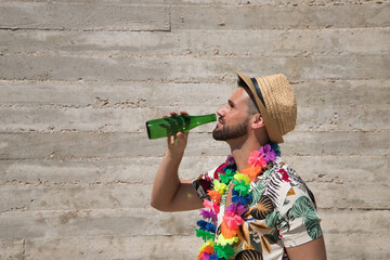 Young and handsome man, blue eyes, with beard, hat, Hawaiian shirt and necklace of flowers and...
