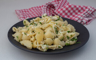 Pasta with cheese on a black plate. Italian Popular Italian food.