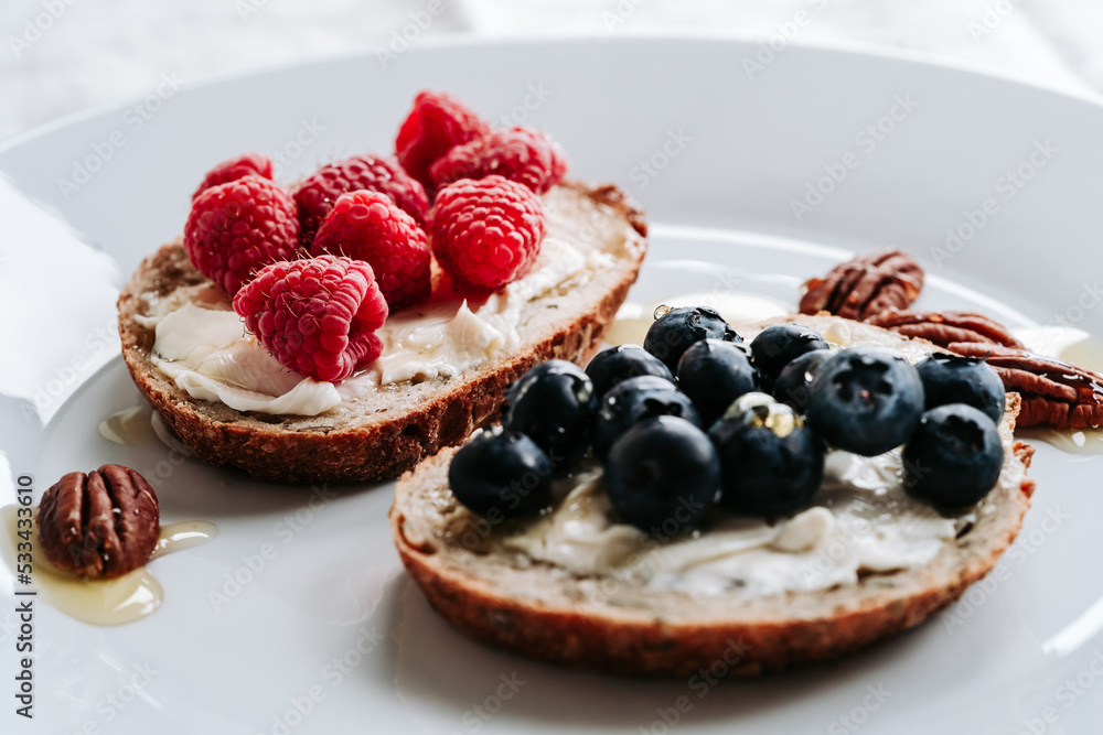 Wall mural Breakfast, sandwiches with cheese spread, blueberry, raspberry fruits, honey and pecan