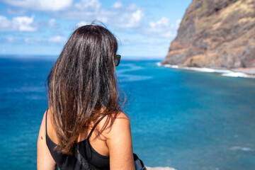 Woman looking at coastline nature on a beautiful island, back view