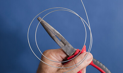  coil of wire, Cutting and holding pliers blue background