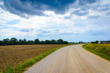Country road and green trees farmland landscape in a summer season.