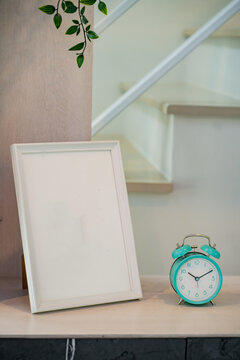 A green clock is placed near the picture frame.