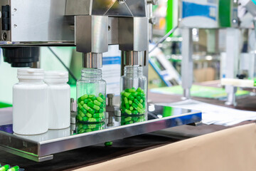 close up white with clear plastic bottle under nozzle dispenser component of automatic medicine...