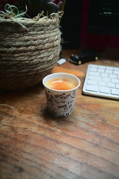 Café sur un bureau avec un pot de fleur ambiance sombre travail portrait
