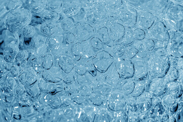 Close up of clear water bubbles in light blue color.