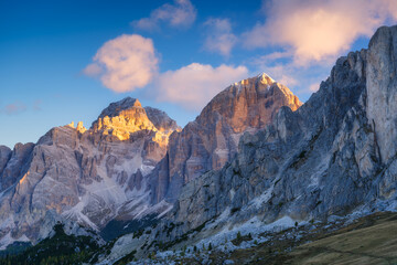 Fototapeta premium Dolomite Alps, Italy. View of the mountains and high cliffs during sunset. High sharp rocks and soft sunshine. Natural landscape. Photo in high resolution.