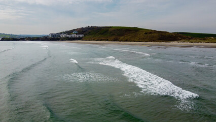 View of Inchydoney beach from the sea at high tide. Beautiful sea waves, surf. Drone point of view.
