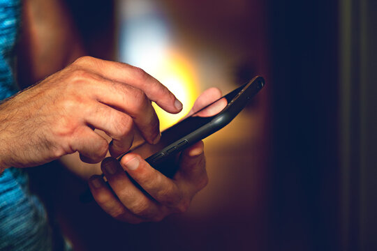 Primer plano de la mano de un hombre sosteniendo su smartphone. Enviando mensajes y compartiendo contenidos en las redes sociales.