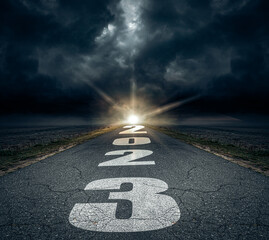 2023 written on highway road in the middle of asphalt road and dark cloudy sky. Future vision 2023