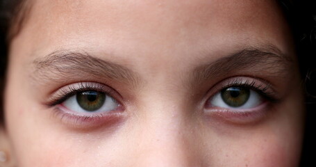 Child green eyes macro close-up. Girl face looking at camera