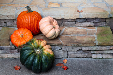 Four colorful pumpkins decorating the front porch in fall.