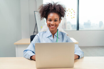 A  African American woman smiles confidently in a modern office.