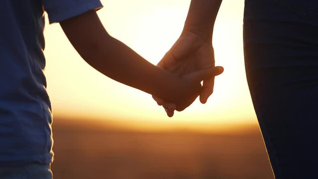 happy family. mom and daughter hold hands close up. mother and baby girl hands together at sunset. parent girl and child happy childhood. lifestyle happy family mothers day concept together
