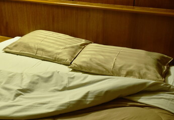 two pillow and  blanket opened for one people on pair bed in night