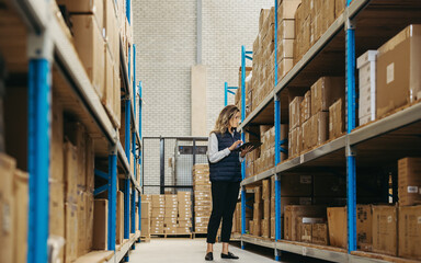 Female warehouse worker doing inventory control using warehouse management software