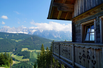 traditional wooden alpine cabin overlooking the vast green alpine valley by the foot of Dachstein mountain in the Austrian Alps of Dachstein-Schladming region (Schladming, Austria)