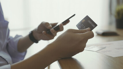 close up of a person working on a laptop with credit card.