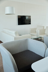Black and grey comfortable velvet armchair standing in front of camera on background of other furniture in spacious openspace office