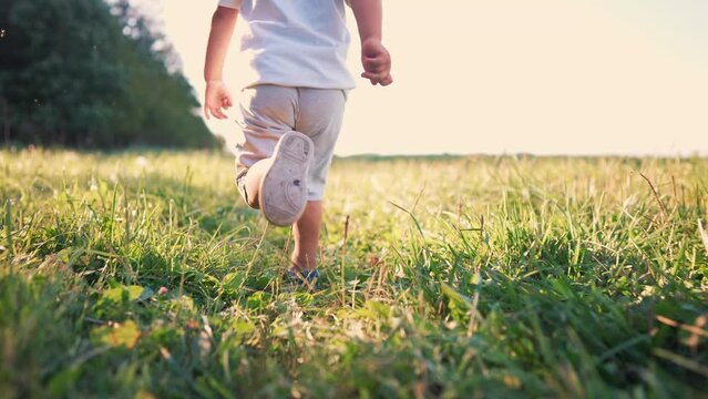 happy family. kid run legs close-up in the park at sunset. people in the park concept boy son joyful running. happy family summer. little kid running. summer kid fun dream concept