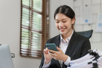 Happy attractive joyful asian woman working at workstation.