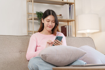 Happy young attractive smiling asian woman enjoying relax time at apartment.