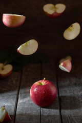 Apple levitation red, cut pieces fly on a wooden background