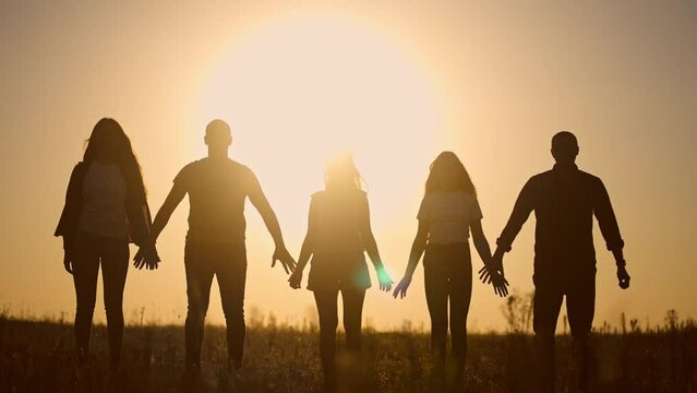 teamwork. team community a holding hands together silhouette at unity sunset. group of people hands. teamwork of workers. team in the company running partnership business community hand lifestyle