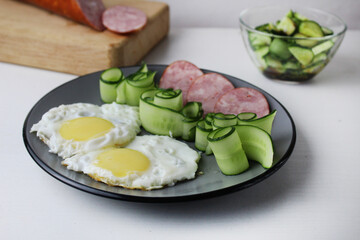 zastrak eggs scrambled eggs sausage salad cucumbers on the trael view from the side top. Traditional English American breakfast. First meal. The benefits of proper nutrition Egg Day. Egg dishes
