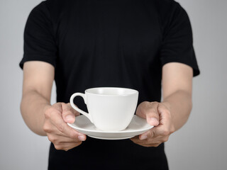 Close up man giving coffee white cup in his hand studio shot