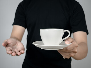 Close-up man hand giving coffee cup studio shot