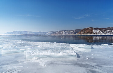 Winter landscape panorama with mountains and Lake Baikal in Siberia on sunny day. Natural background.