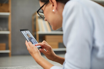 Business woman in glasses giving a like to man's photo in mobile dating app on smartphone screen. Single woman looking for love relationship online. Searching romantic partner in social app concept