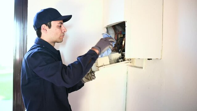 Smiling technician repairing an hot-water heater