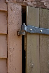 Old wrought iron hinge mounted on wood plank door