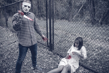 A serial killer scene is about to kill an Asian woman,concept thriller scene,Halloween festival
