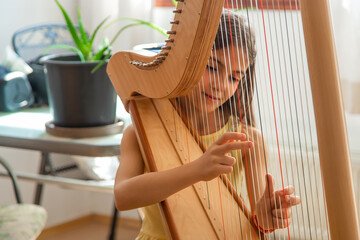 The child plays the harp. Selective focus.