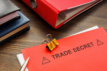 Papers with trade secret and a red folder. - obrazy, fototapety, plakaty