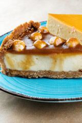 Nut vanilla cheesecake with salty homemade caramel on a blue plate.