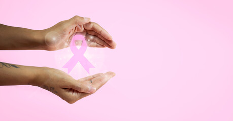 Fototapeta Banner con manos de mujer sosteniendo un lazo rosa por el mes de concientización sobre el cáncer de mama. obraz