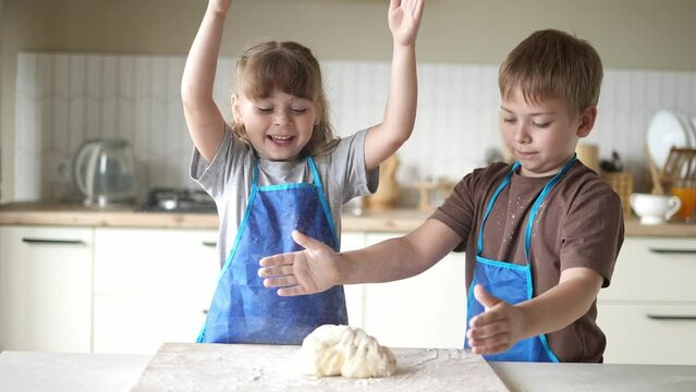 children kids making dough in the kitchen. baby boy cook in the kitchen knead dough and flour indoors. happy family kid dream concept. children play cooking dough lifestyle together at home