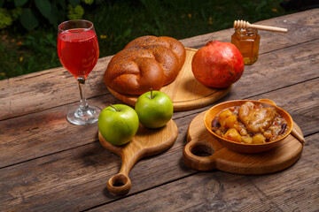 Challah pomegranate and honey on wooden boards for Rosh Hashanah.