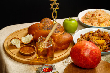 Festive table Rosh hashanah challah honey apples wine pomegranate traditional food and burning...