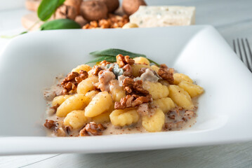Piatto di deliziosi gnocchi di patate conditi con gorgonzola e noci, pasta italiana 