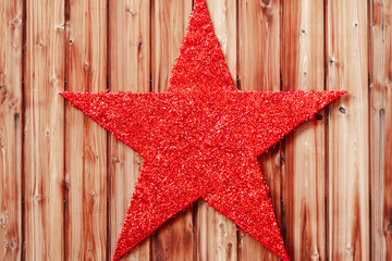 Red Glitter Christmas star on isolated wooden background