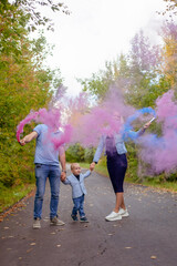 Fototapeta premium little boy with parents on gender party with colorful smoke