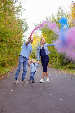 Little Boy With Parents On Gender Party With Colorful Smoke