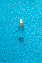 Bottle of cosmetics and drops of liquid, moisturizing. Hyaluronic acid. Selective focus.
