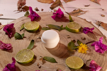 Frasco de crema blanco, sin marca con hojas verdes y rebanadas de limón