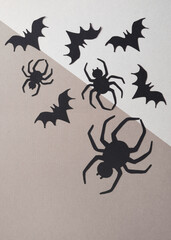 Halloween Background with Black Spiders and Bats. Big Black Spiders and Little Flying Bats on a Geometric White-Brown Background. Halloween Flat Lay. Top View Composition ideal for Banner, Flyer.